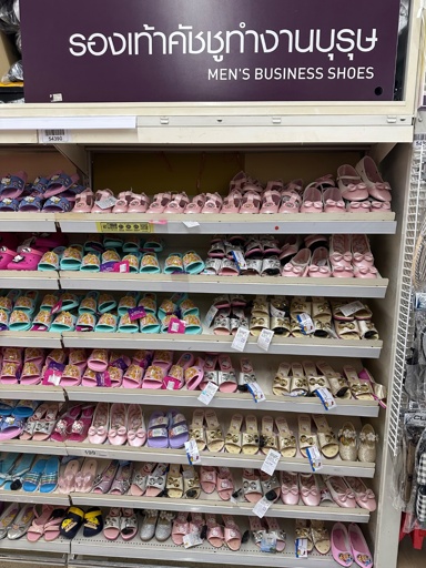 Photo of a store shelf labeled “Men’s Business Shoes”. The rack is full of pink, purple, and silver children’s shoes. Many of which have Disney princess and hello kitty themes